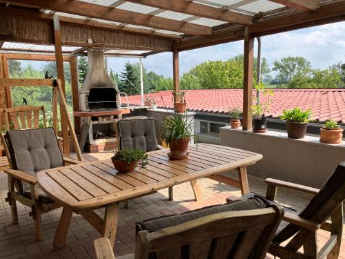 a wooden table and chairs on a patio with a fireplace at Pension Volgenandt in Breitenbach