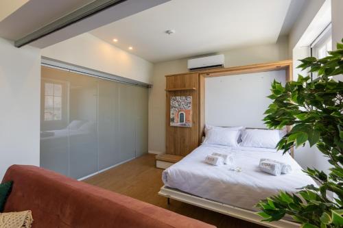 ein Schlafzimmer mit einem Bett und einer Couch in der Unterkunft BESTVILLAS Plaza in Braga