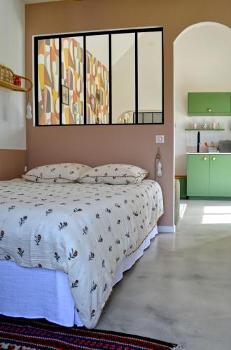 a bedroom with a bed and a large window at La petite maison de Celestine in Plonéour-Lanvern