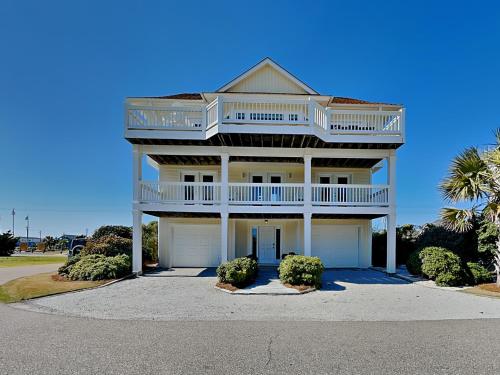 a large white house with a balcony and two garage at The Shell Collector in Surf City