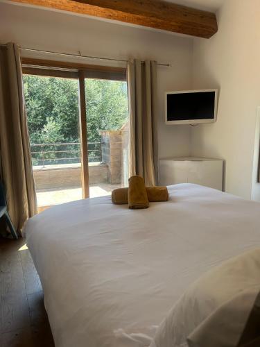 une chambre avec un grand lit blanc avec une grande fenêtre dans l'établissement magnifique villa à Précojo, à Porto-Vecchio