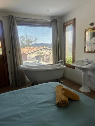 une salle de bain avec une baignoire et un lavabo et un lit dans l'établissement magnifique villa à Précojo, à Porto-Vecchio