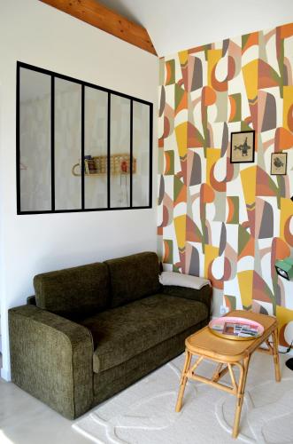 a living room with a couch and a table at La petite maison de Celestine in Plonéour-Lanvern