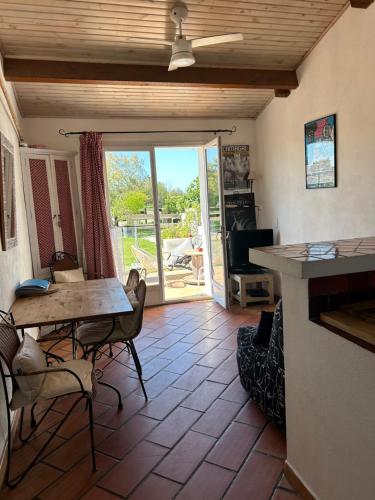 ein Wohnzimmer mit einem Tisch und Stühlen sowie eine Terrasse in der Unterkunft Gite Armieux in Saintes-Maries-de-la-Mer