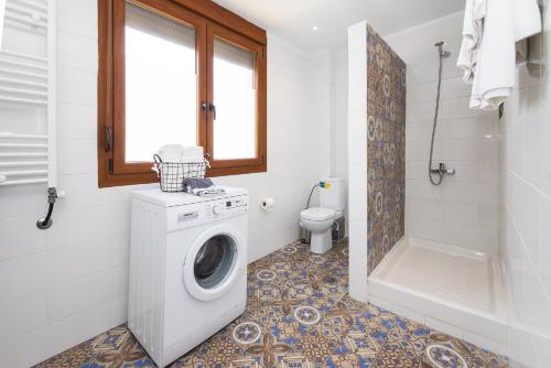 a bathroom with a washing machine and a toilet at Kallikratia Suites 3 in Nea Kalikratia