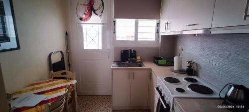 a small kitchen with a stove and a sink at Lefterakis place in Aegina Town