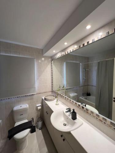 a bathroom with a sink and a toilet and a mirror at 201 Apartment-A perfect escape in Paphos