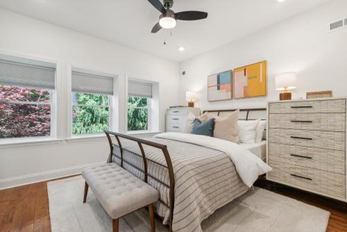 Un dormitorio con una cama, una cómoda y ventanas. en Family Friendly in the Heart of Mt Airy, en Filadelfia