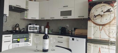 a bottle of wine sitting on a table with a clock at Apartament Turysty Zamczysko in Zamość