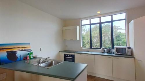 a kitchen with a sink and a counter top at Big Save at St Lukes Quiet House in Auckland