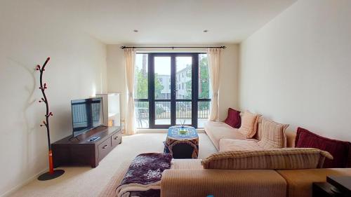 a living room with a couch and a tv at Big Save at St Lukes Quiet House in Auckland