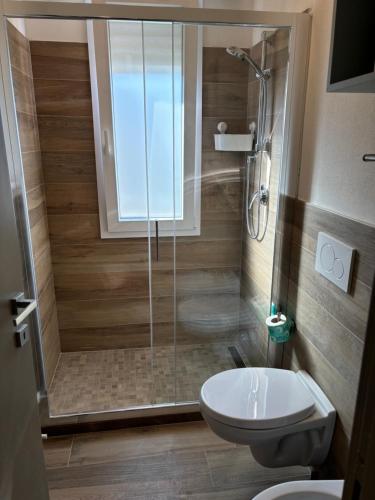 a bathroom with a shower and a toilet and a sink at Lugano 41 by ALEhotels in Rimini