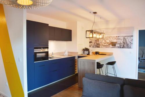 a kitchen with blue cabinets and a counter top at SweetHomeVersailles 10mn walk from Palace in Versailles