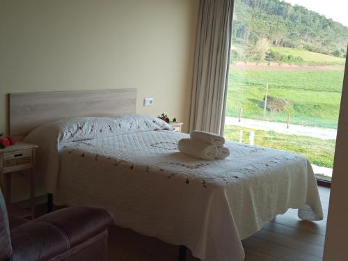 ein Schlafzimmer mit einem weißen Bett mit einem Fenster in der Unterkunft Camping Playa de Nemiña in Nemiña