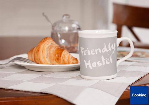 a coffee cup and a plate of bread on a table at Friendly Hostel in Gjirokastër
