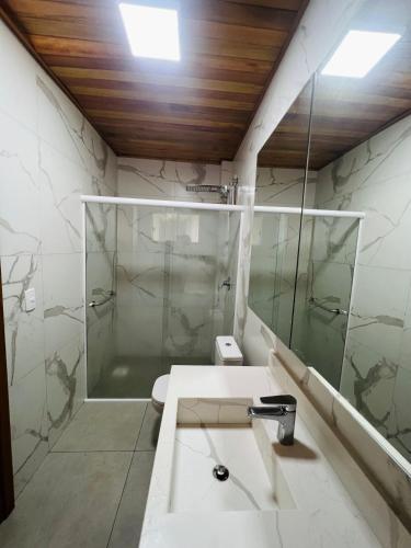 a bathroom with a sink and a shower at Pousada Boulevard in São Joaquim