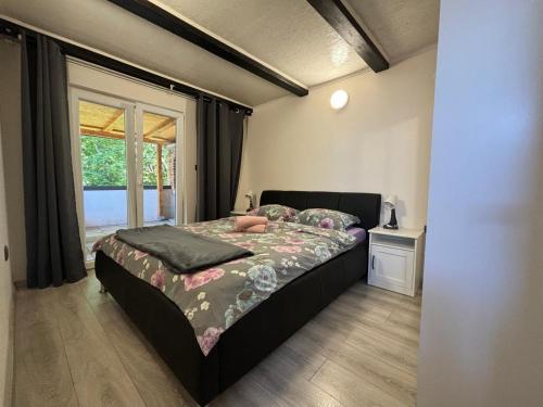 a bedroom with a bed and a window at Apartmani Bošnjak in Starigrad-Paklenica