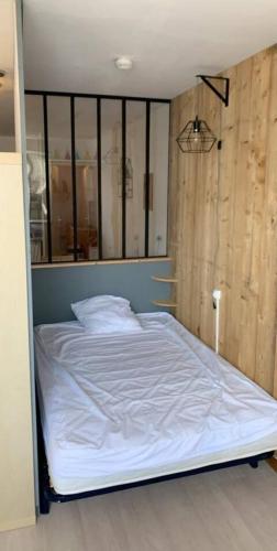 une chambre avec un lit dans une chambre avec un mur dans l'établissement Superbe T1 Bis proche du Centre Ville et Plage, à La Rochelle