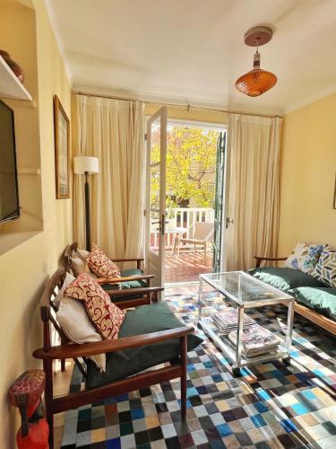 a living room with a couch and a glass table at Pato’s Guest House in Mendoza
