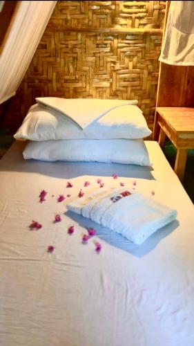 a bed with pink rose petals on the sheets at Bohol Island Homestay in Dauis