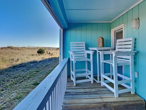 a porch with two chairs and a bar on a house at A Place At The Beach #1D in Carolina Beach