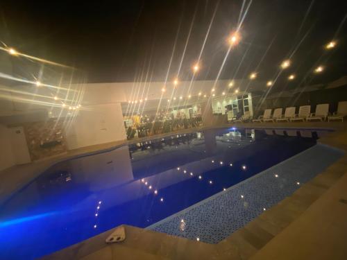 a large swimming pool at night with chairs and lights at Hotel deluxe oasis de la colina boutique in Girardot