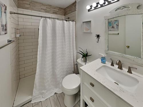 a white bathroom with a toilet and a sink at A Place At The Beach #1D in Carolina Beach