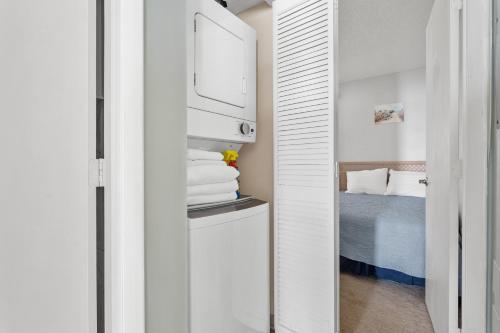 a small room with a bed and a white closet at A Wave From It All in North Topsail Beach