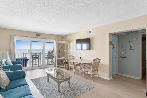 a living room with a blue couch and a table at A Wave From It All in North Topsail Beach