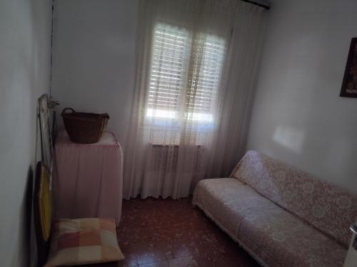 a room with a window with a couch and a table at Ca la conxita in Tona
