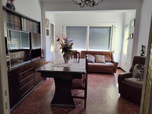 a living room with a table with a vase of flowers on it at Ca la conxita in Tona