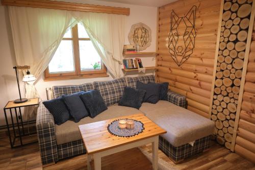 a living room with a couch and a table at Bieszczadzka Samotnia in Cisna
