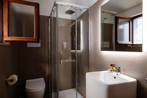 a bathroom with a shower and a sink and a toilet at IL CASTELLO affittacamere in Posada