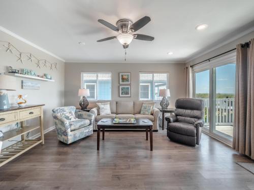 a living room with a couch and a chair at Coral Surf #A1 - Beachy Keen in Carolina Beach