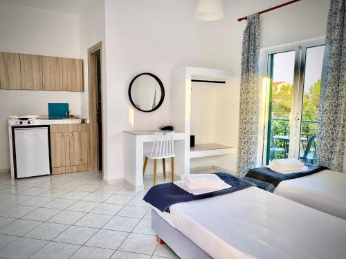um quarto de hotel com duas camas e uma cozinha em Fardini Seaside Hotel em Kavos