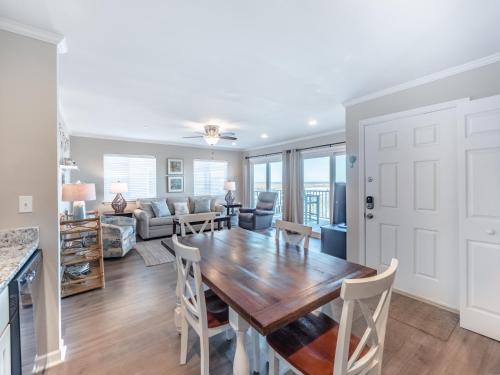 a kitchen and living room with a wooden table and chairs at Coral Surf #A1 - Beachy Keen in Carolina Beach