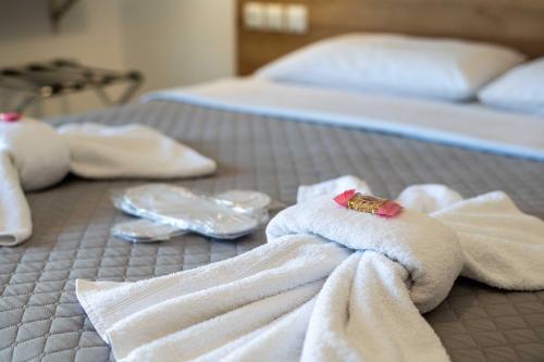 a bed with white towels and dishes on it at Finikas Suites & Apartments Airport By Airstay in Artemida