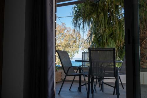 a patio with chairs and a table with a view of the ocean at Finikas Suites & Apartments Airport By Airstay in Artemida