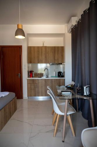 a kitchen with a table and chairs in a room at Finikas Suites & Apartments Airport By Airstay in Artemida