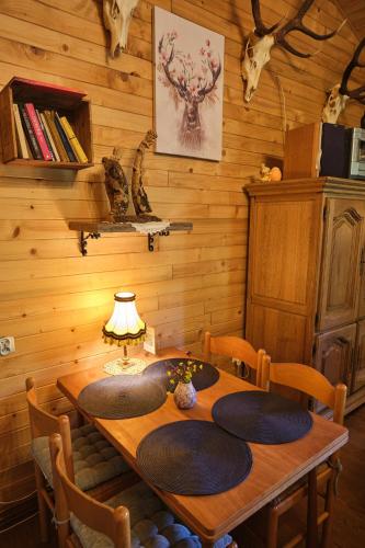 a wooden dining room table with chairs and a lamp at Bieszczadzka Samotnia in Cisna