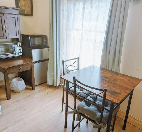 a kitchen with a table and chairs and a table and a microwave at Walkable Uptown area, King Suite, Quiet and Private in Charlotte
