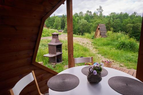 a table and chairs in a room with a window at Bieszczadzka Samotnia in Cisna