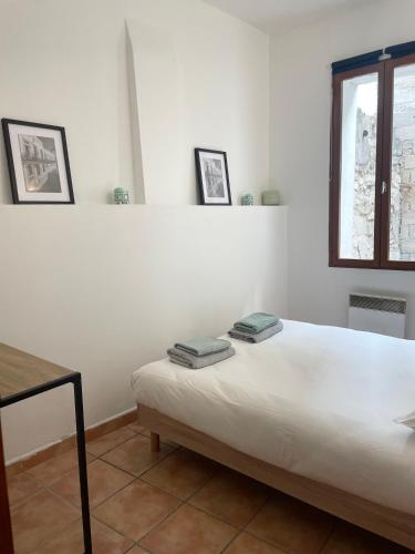 - une chambre blanche avec un lit et 2 serviettes dans l'établissement Appartement Avignon intra-muros, à Avignon