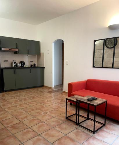 un salon avec un canapé rouge et une table dans l'établissement Appartement Avignon intra-muros, à Avignon