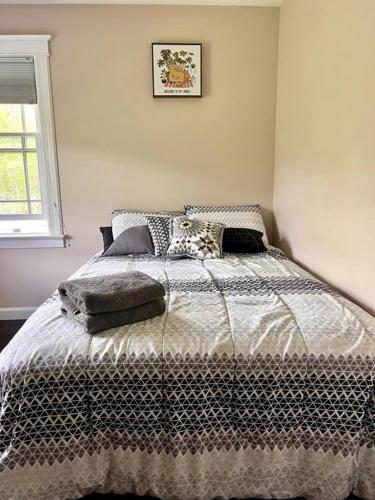 a bedroom with a bed with a picture on the wall at Experience the Charm of a Cozy Hudson Valley Vacation Retreat in Gardiner