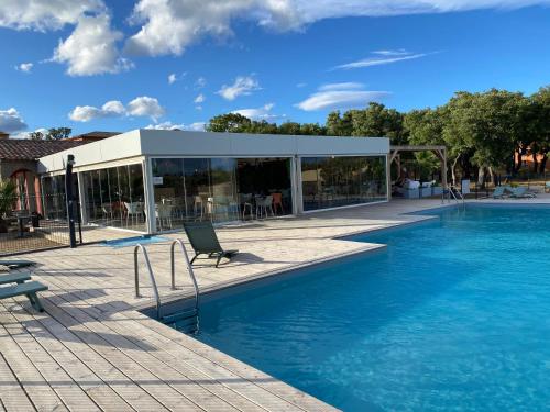 - une piscine avec une chaise à côté d'un bâtiment dans l'établissement Appartement 2 pièces dans une résidence hôtelière Les Hameaux de Saint-Cyprien, à Lecci