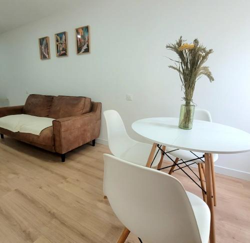 a living room with a table and chairs and a couch at Jolie maison de vacances 4-5 personnes in Saint-Marcel