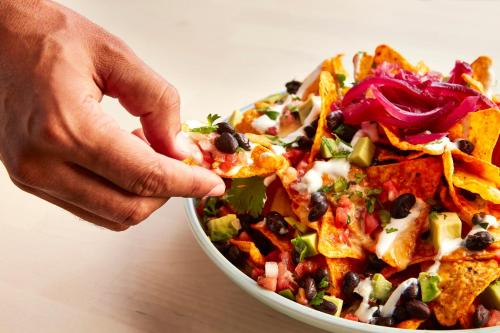 a person taking a bite out of a salad at Holiday Inn Grand Rapids-Airport by IHG in Grand Rapids