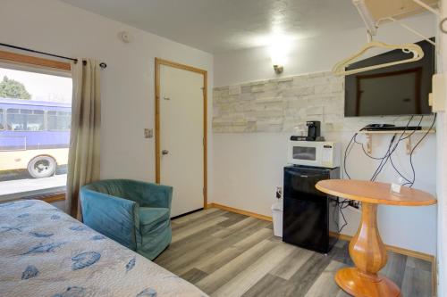 Habitación con cama, mesa y TV. en Westerly Motel en Ocean Shores