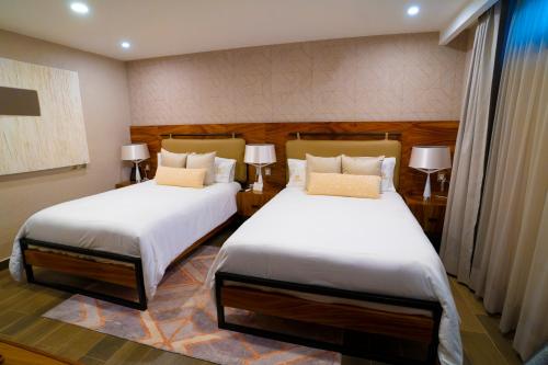 a bedroom with two beds and two lamps at Hotel Boutique Corazón Mexicano in Guanajuato